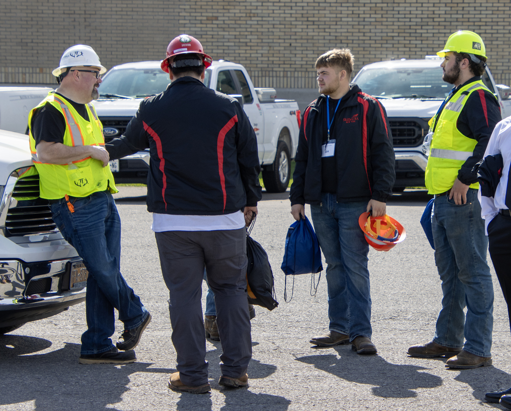Competition supervisor speaks to students in the heavy equipment area of SkillsUSA