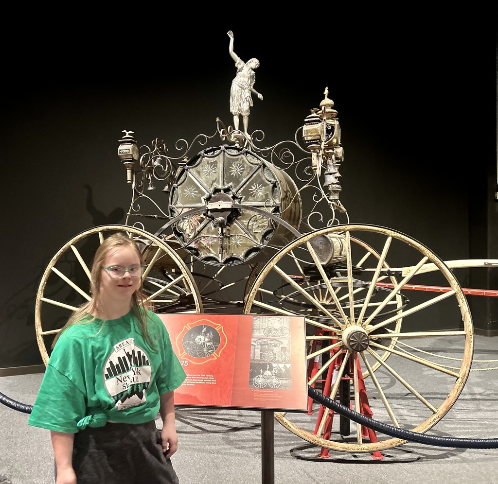 student poses with antique fire engine