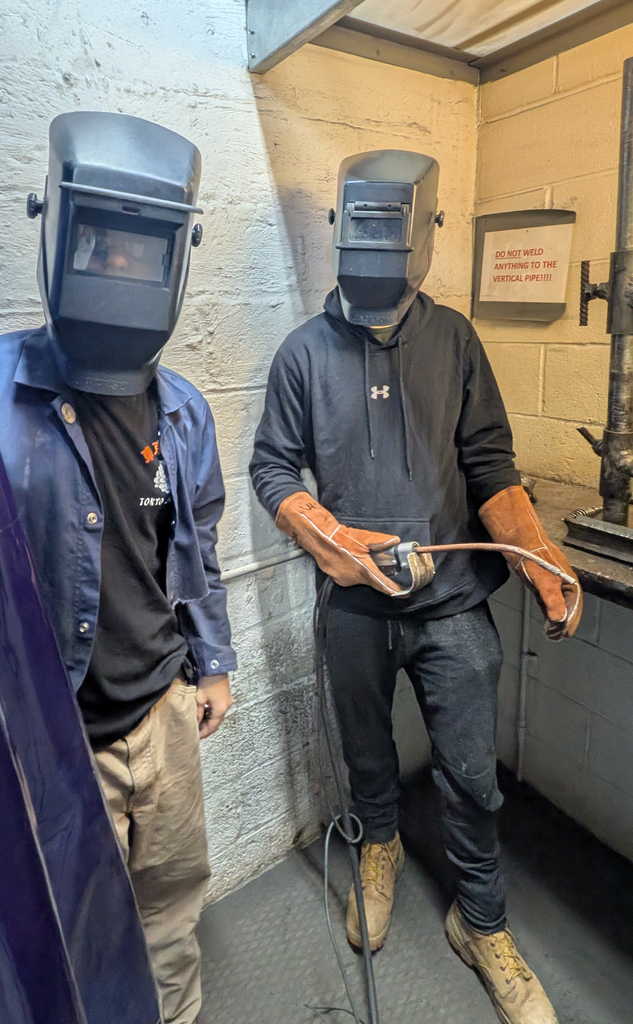 2 students in welding helmets