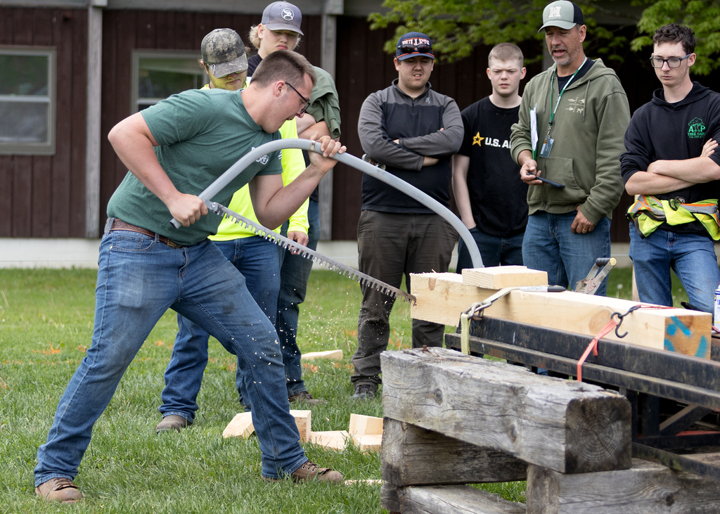 student sawing with a bow saw