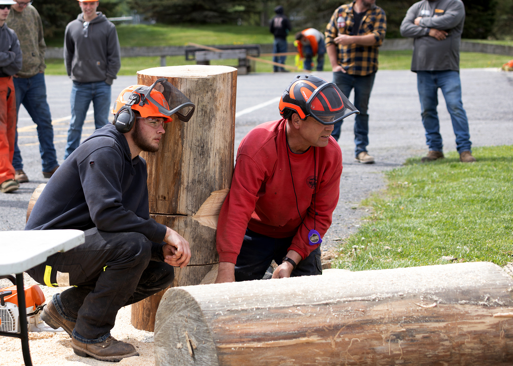 2 students wearing protective gear waiting in  the tree felling competition