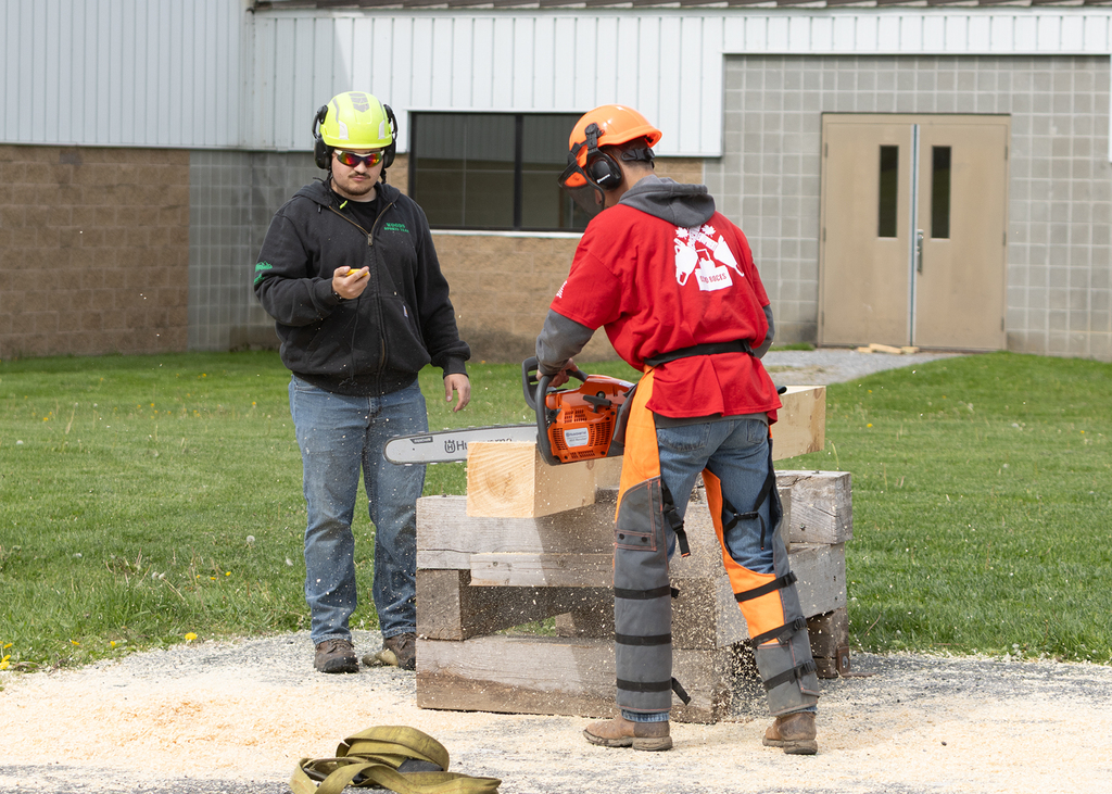Judge timing a student making chainsaw cut