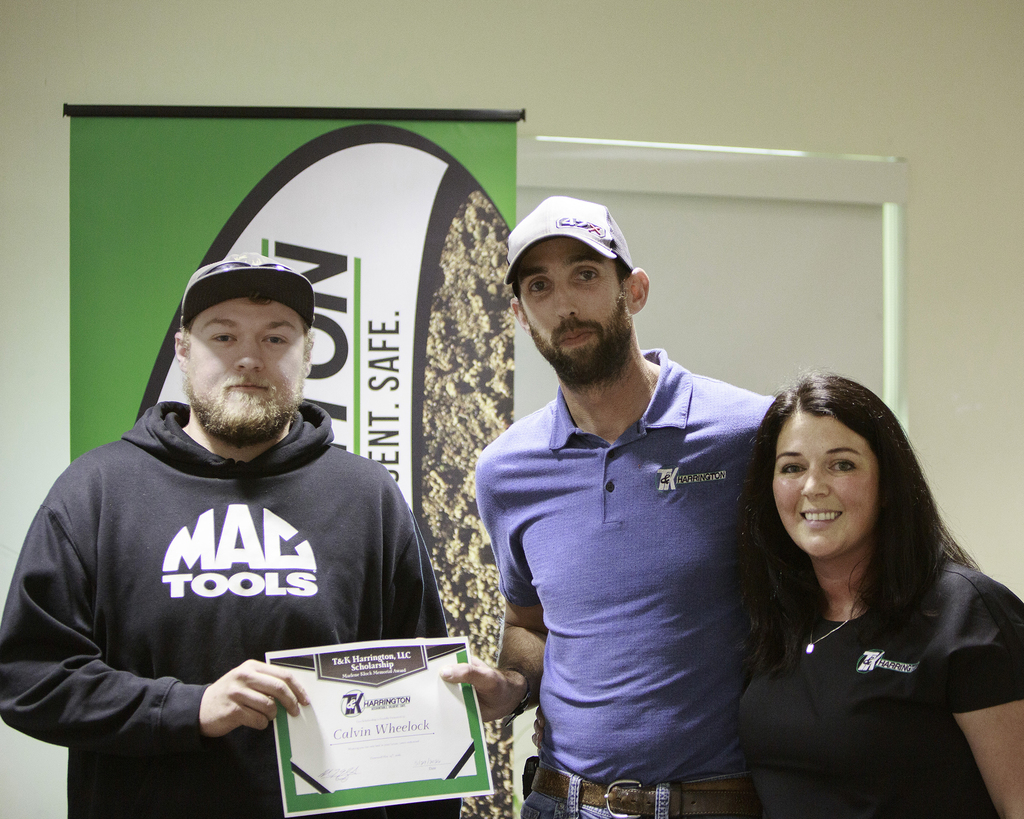 Calvin Wheelock receives a certificate from two representatives of T & K Harrington