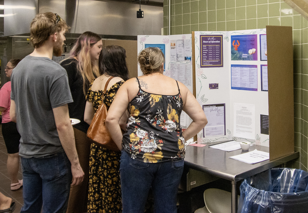 student and family members looking at a display in the culinary kitchen