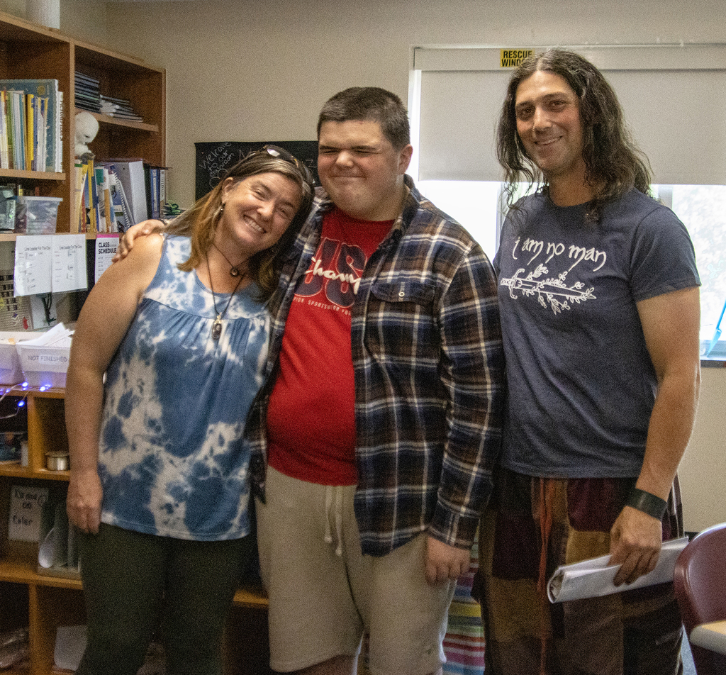 student poses with parents, all are smiling