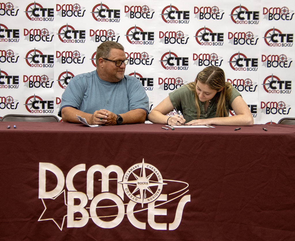 student signing a commitment letter