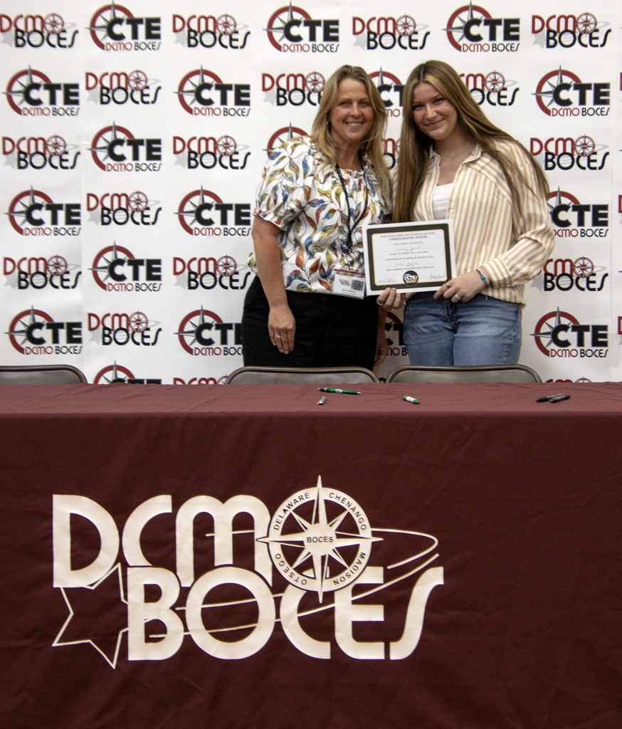 student with their future employer and a commitment certificate