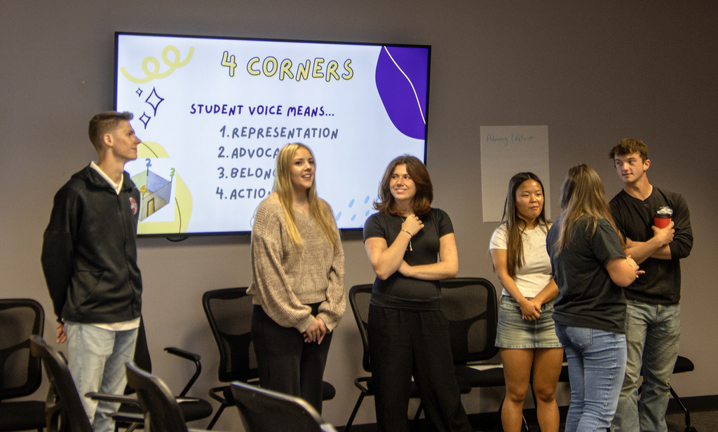 6 students speaking in front of a screen