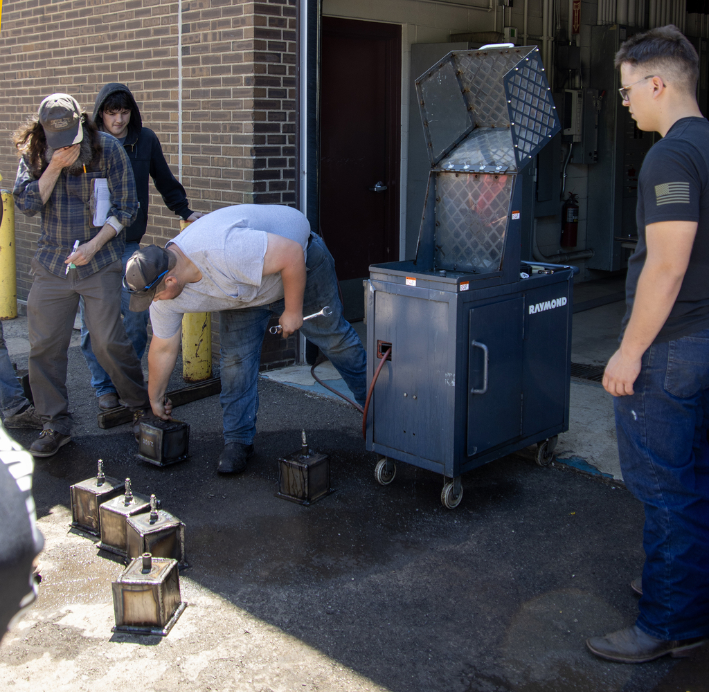 Tyler Reynolds lifts a steel box for testing