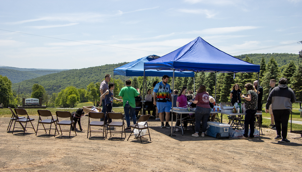 picnic outside under shade shelters with DCMO BOCES sign in background