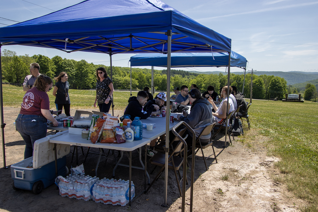picnic outside under shade shelters with DCMO BOCES sign in background