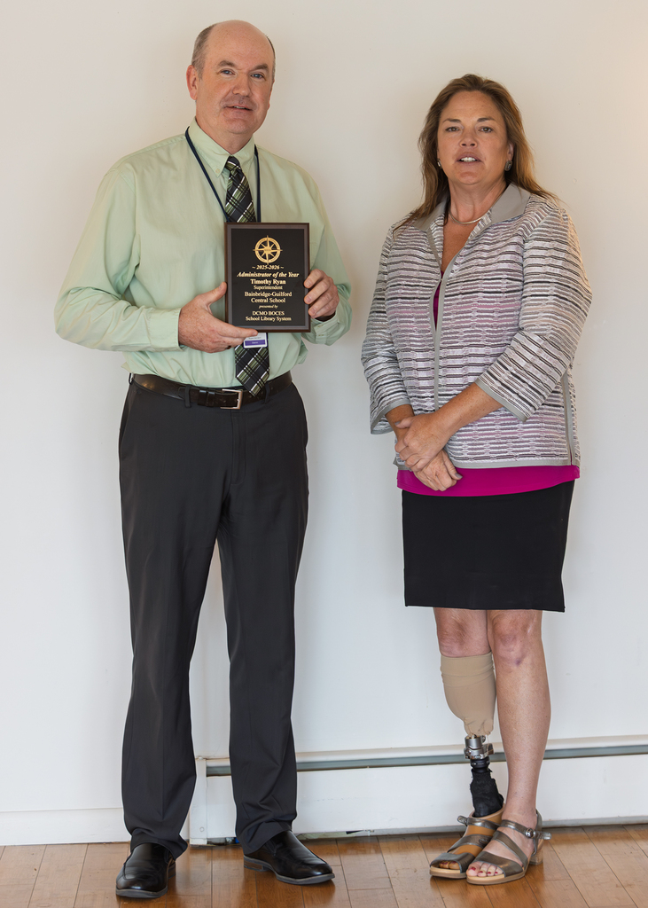 Tim ryan, holding plaque, and Betsy Hartnett