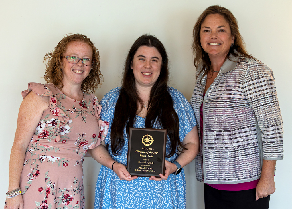Sarah Gaeta holds her plaque, flanked by two people