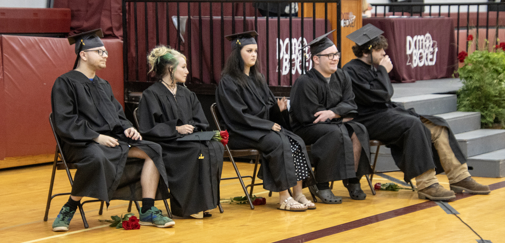 seniors sitting in caps and gowns