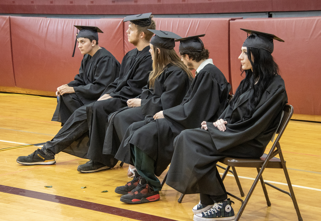 seniors sitting in caps and gowns