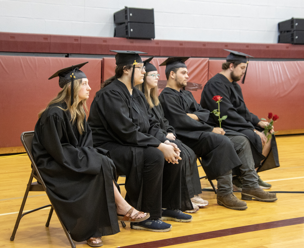 seniors sitting in caps and gowns