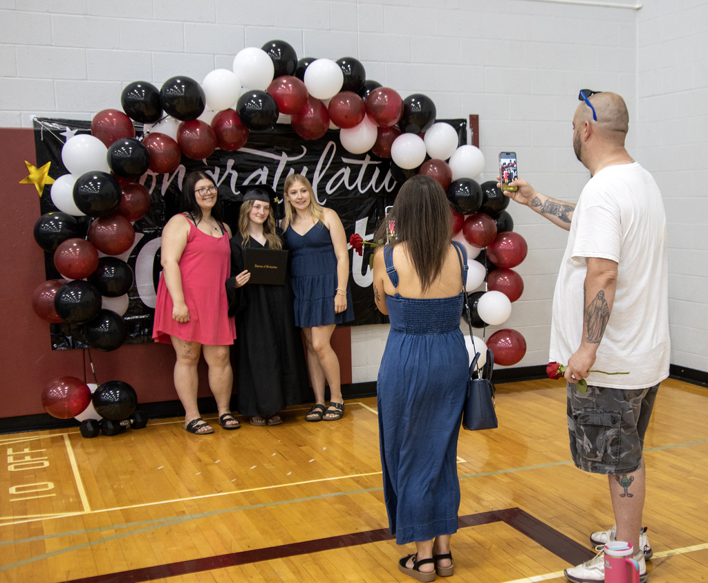 senior posing for pictures with friends at graduation