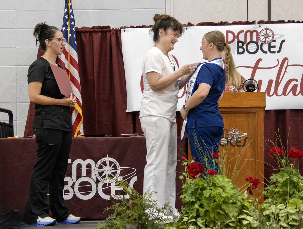 teachers pinning nurse assisting student