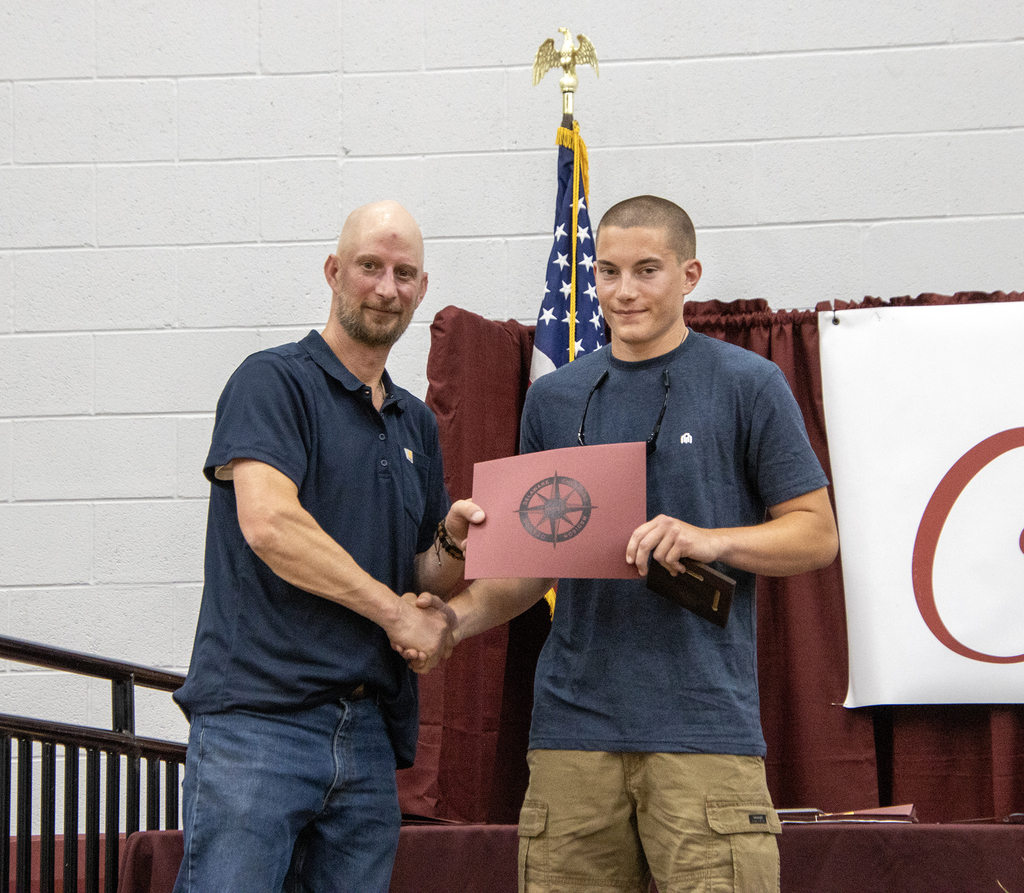 Carpentry teacher handshake with student
