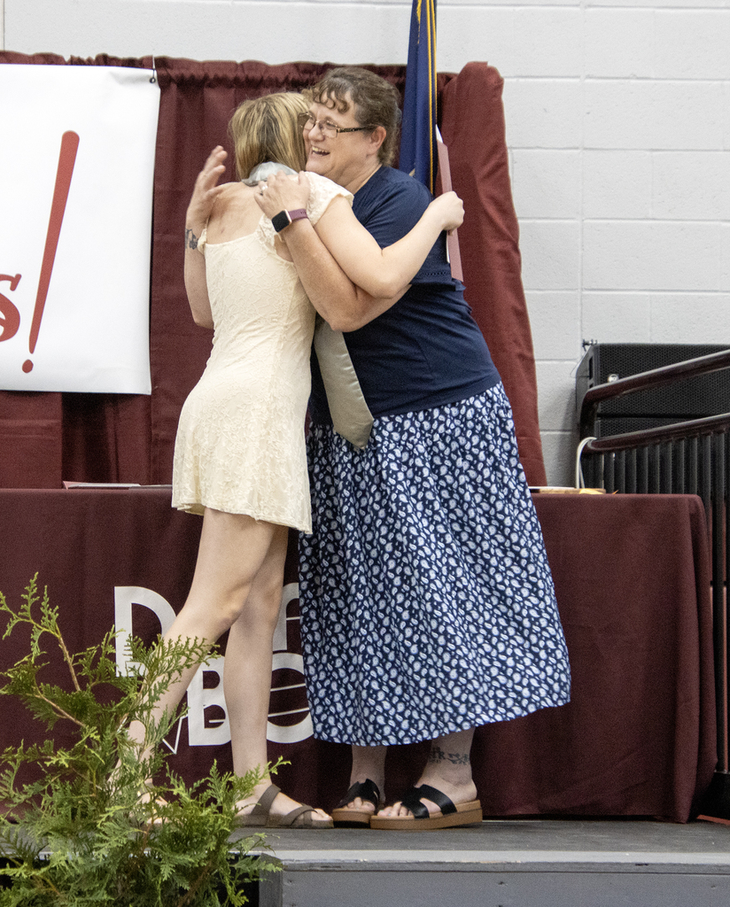 student hugging culinary arts teacher