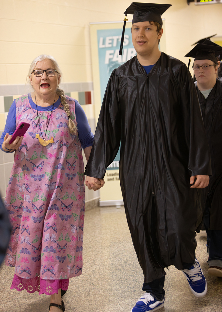 aide walks with student on senior walk