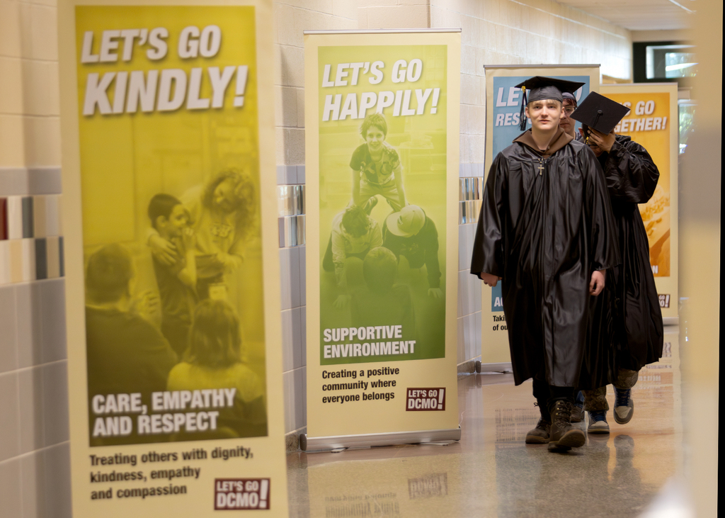 students in caps and gowns on senior walk