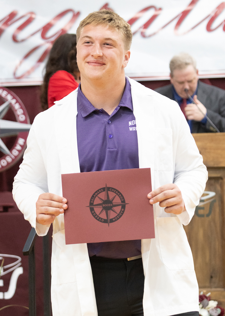 student poses with his certificate