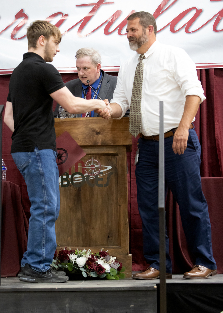 teacher shakes student's hand on stage