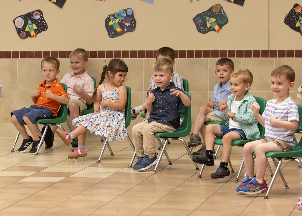 preschool children sitting and doing hand gestures