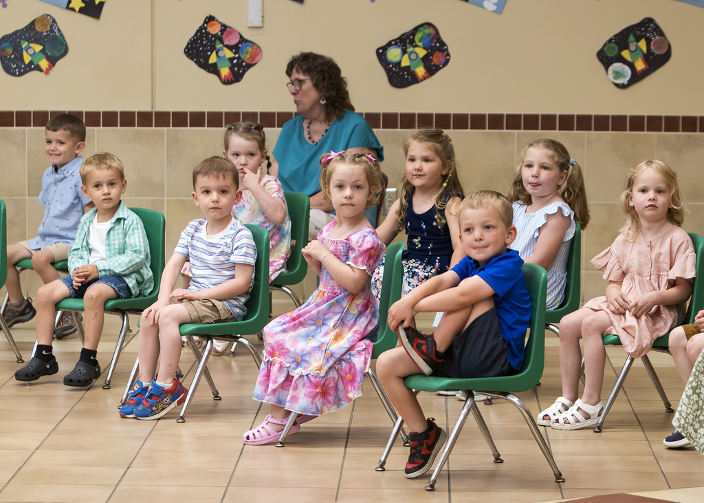 preschool children sitting in chairs