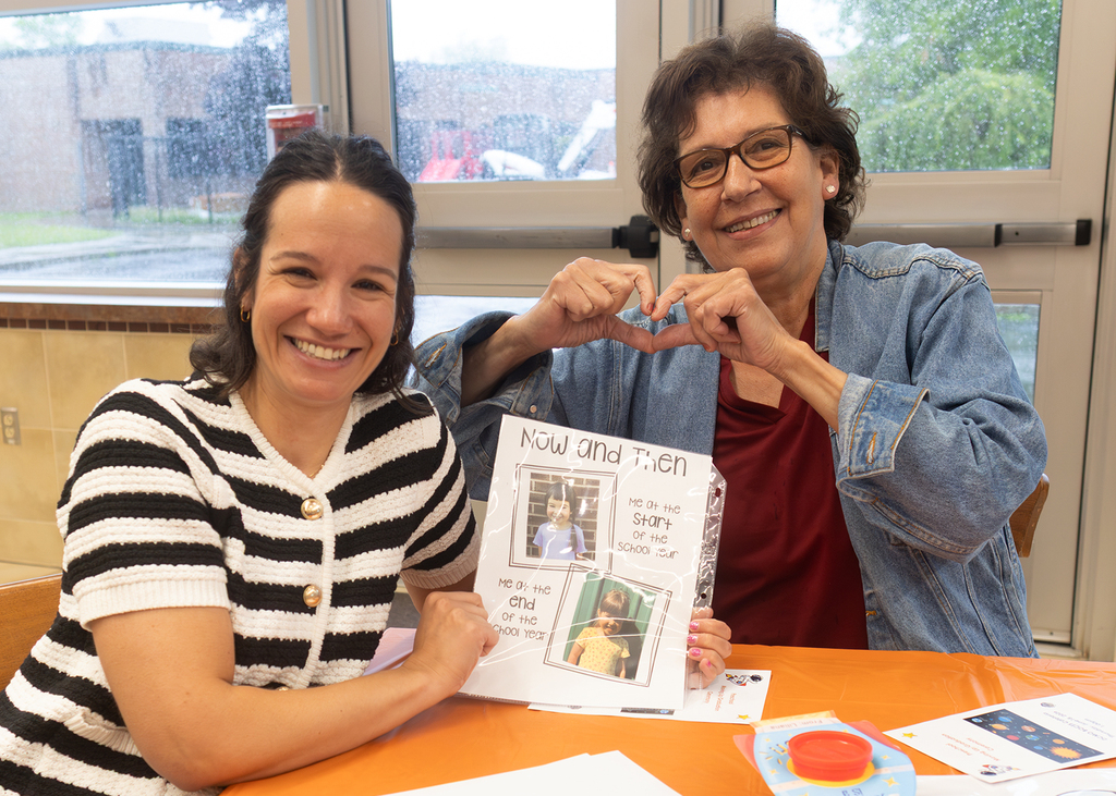 2 guests at the preschool moving up ceremony with a "now and then" page