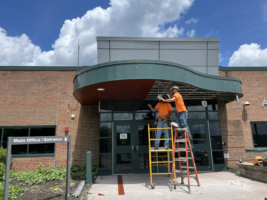 2 workers repairing overhang soffit at Pole Campus