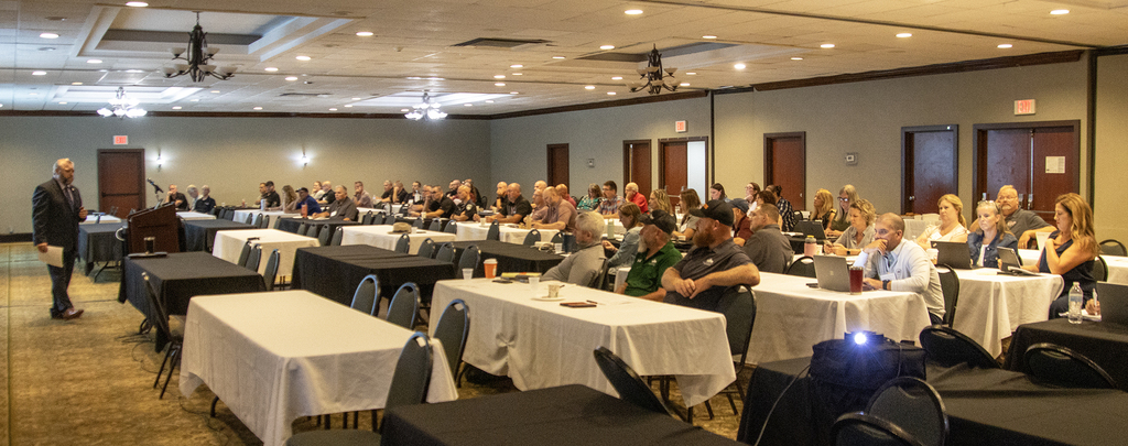 speaker in front of large audience in banquet room