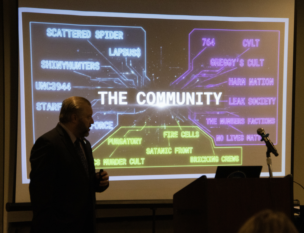 Speaker in front of screen that says "the community"