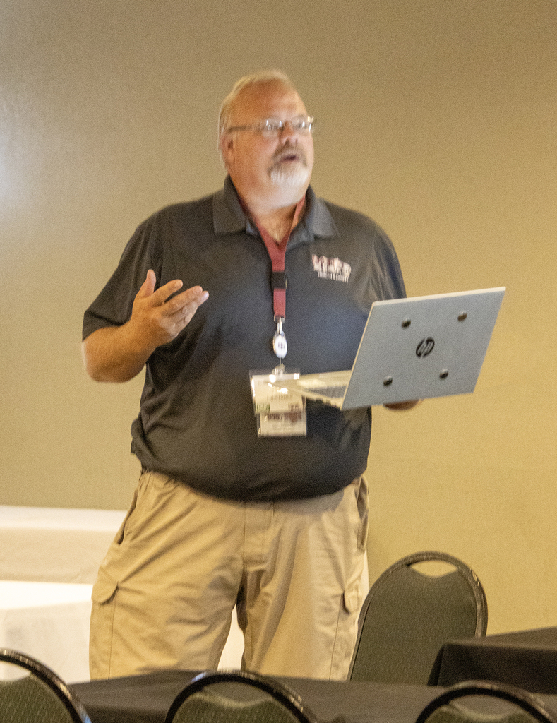 Jason Lawrence speaking while hold a laptop