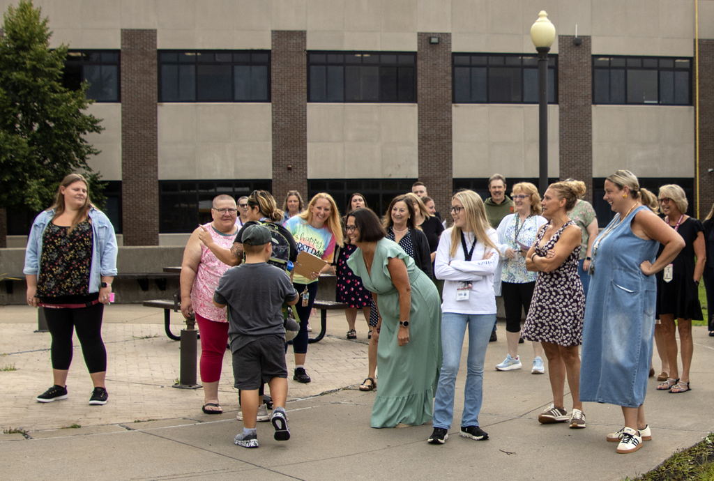Staff greet a student as he arrives at Harrold Campus