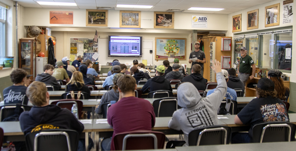 Conservation students in classroom; one student raising hand
