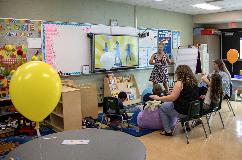 Specail Education teacher leading class in an activity; balloons are around the room