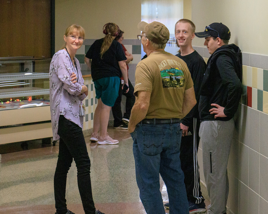 a smiling fammily speaking to a teacher or staff member