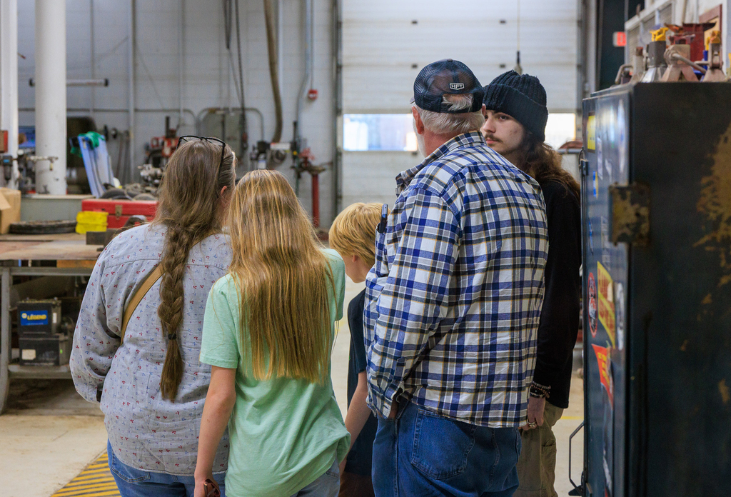 a family is shown in the auto technologies shop