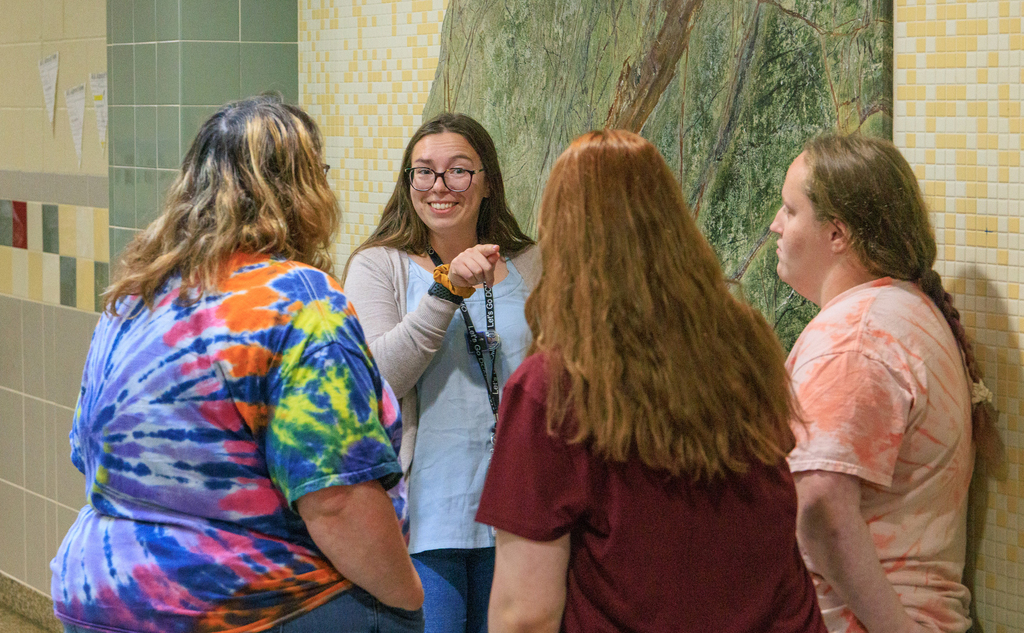 smiling teacher speaks to a family