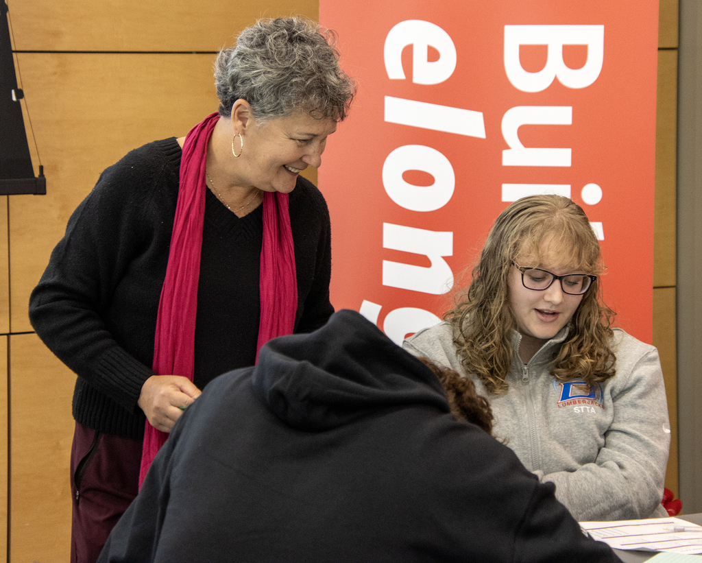 Martha Ryan smiling and speaking to a student