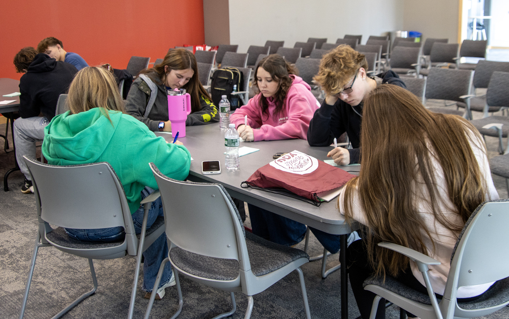 7 students working on a questionnaire at tables