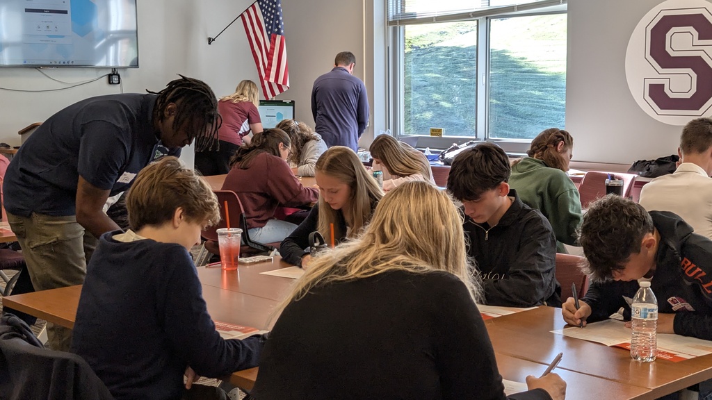 students work at tables in a school room