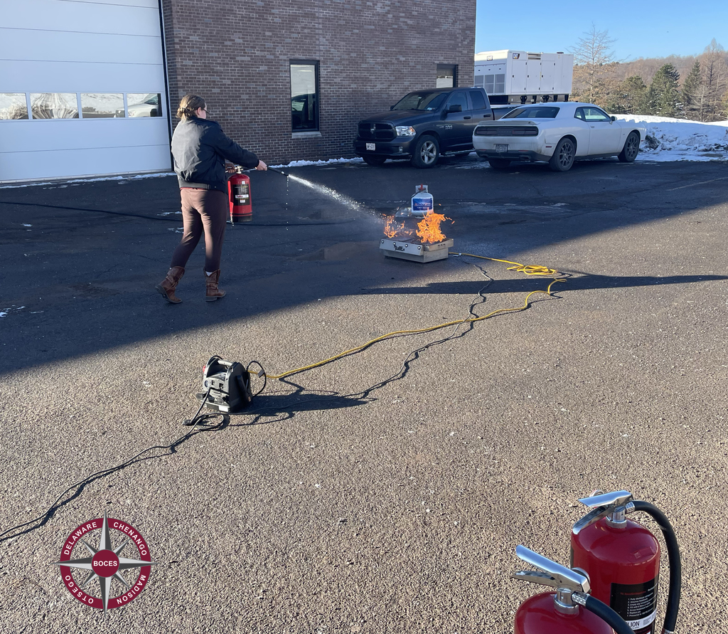 student using fire extinguisher on flames