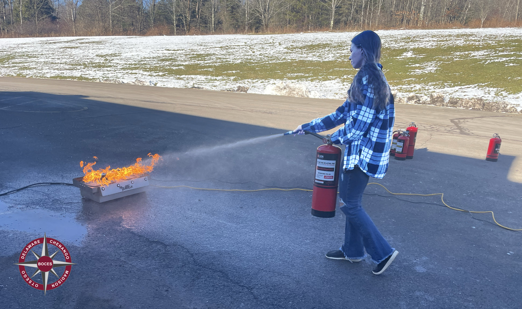 student using fire extinguisher on flames