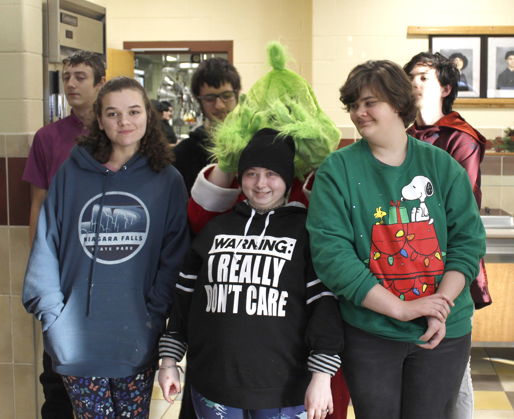 3 students pose with Grinch