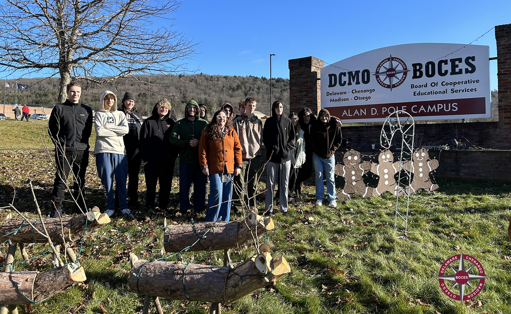 students and staff installing lioghts in front of the DCMO BOCES sign