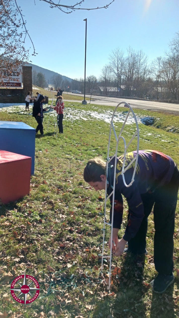 students and staff installing lioghts in front of the DCMO BOCES sign
