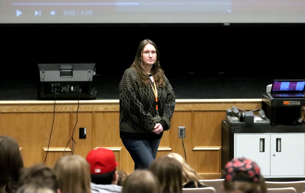 adult presenter standing in front of auditorium